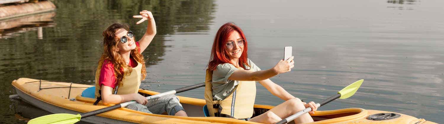Two young women in a kayak, taking a selfie