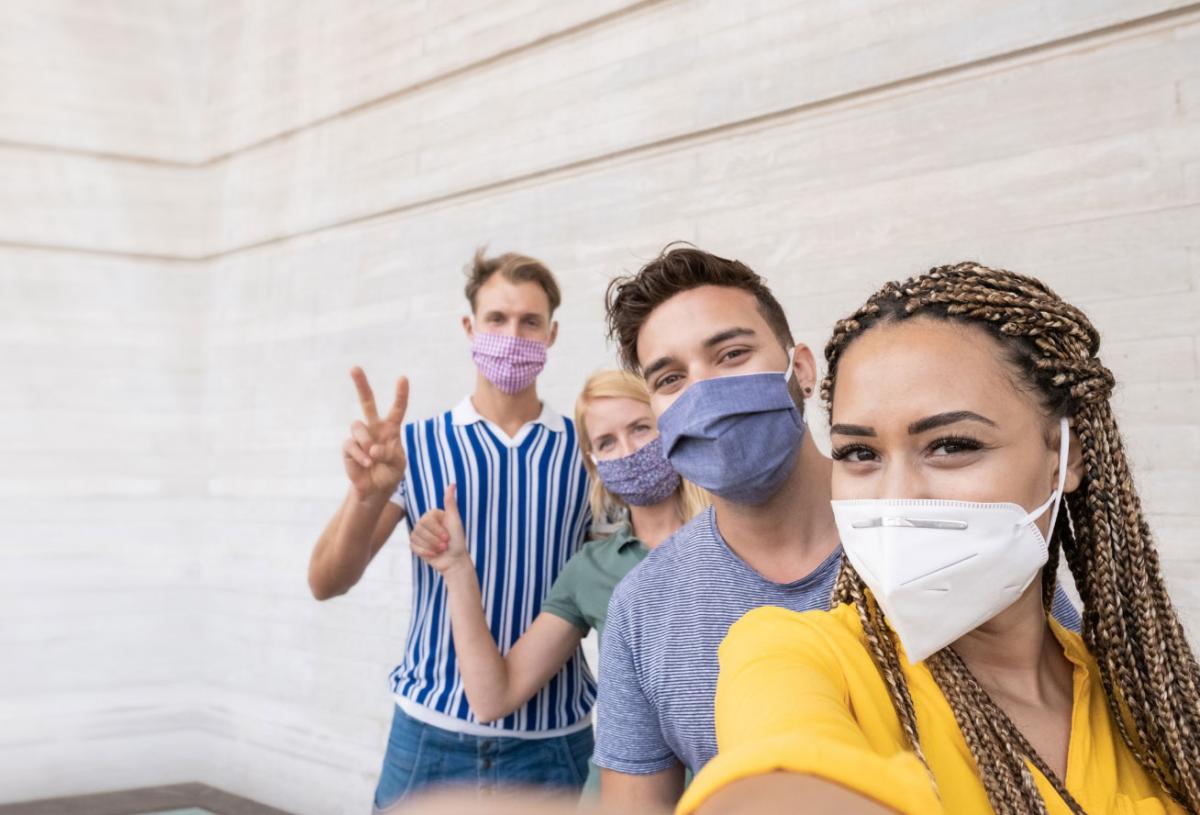 Four friends wearing masks taking a selfie. 